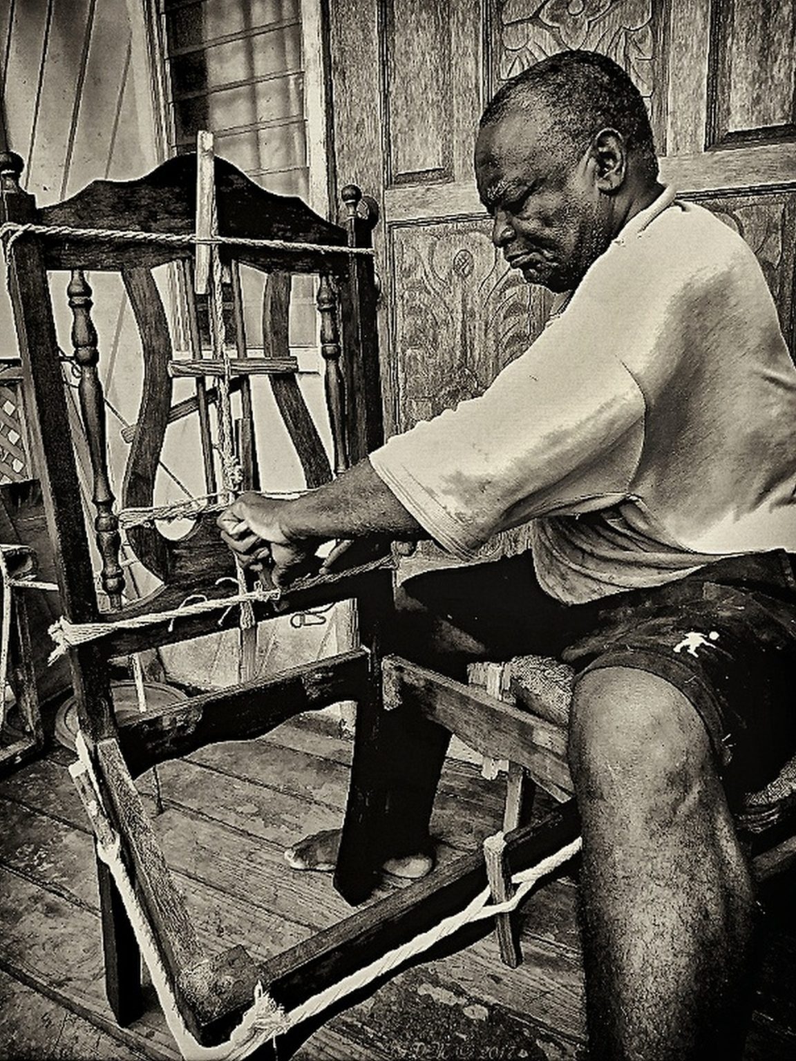 In a quiet Barbadian home, a craftsman works patiently with practised hands, weaving new life into a chair worn by years of use. The image is more than a portrait of labour; it is a reflection of continuity, of knowledge, skill, and tradition carried through generations by hand.