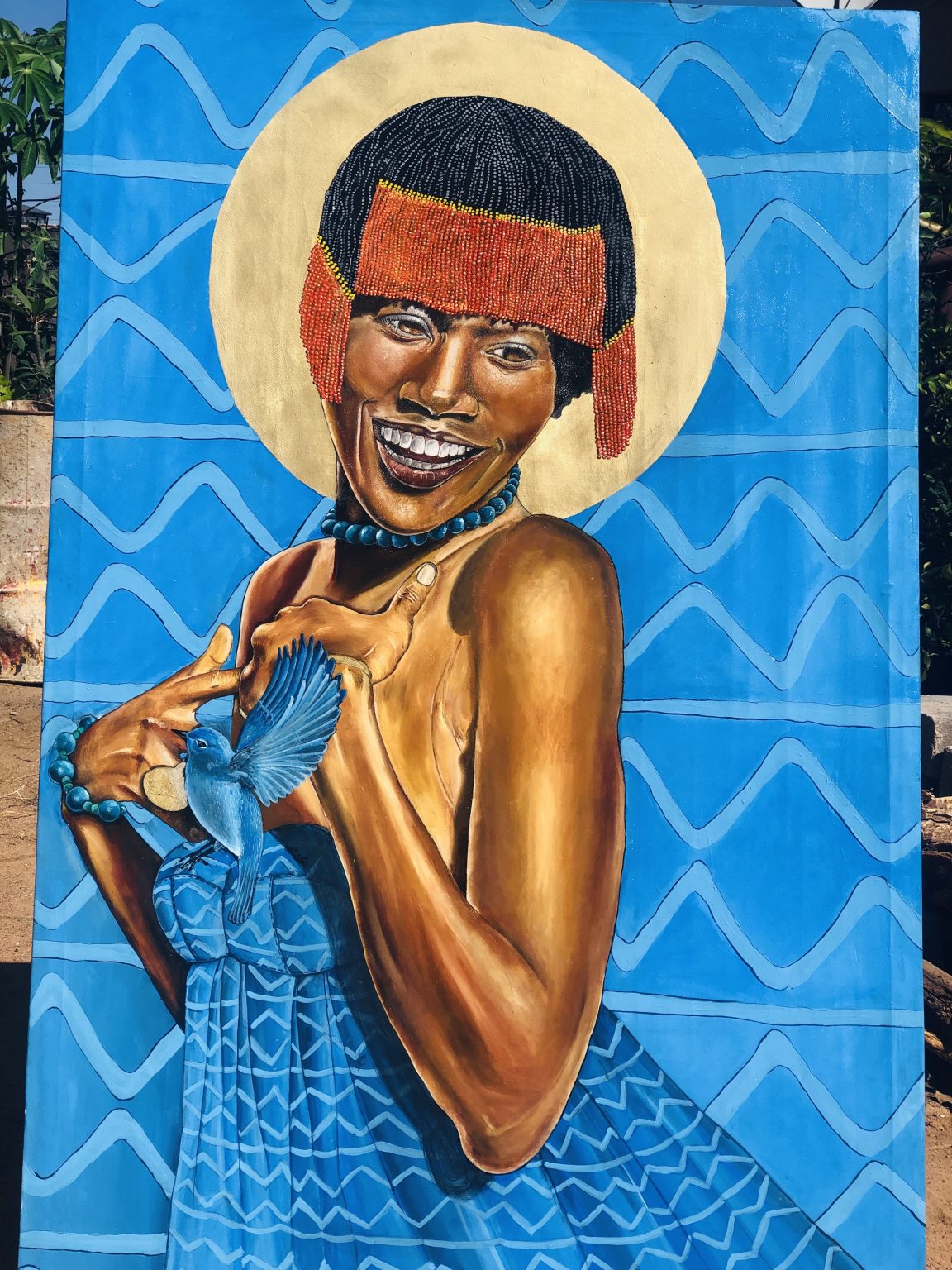 This portrait of Kaone Kario is rooted in Botswana. The vivid blue that dominates the painting speaks directly to Botswana’s flag and sky - Pula, rain and blessing. The geometric print on Kaone’s dress is deliberately mirrored in the background, visually binding her to her homela