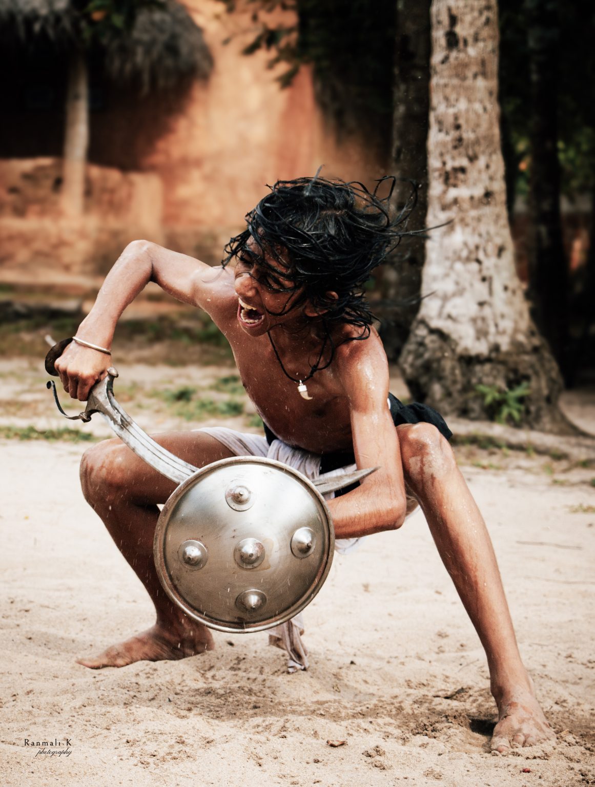 Angampora is a traditional martial arts form native to Sri Lanka. It combines both armed and unarmed combat as well as yoga and meditation. The photo shows a young child in training at a martial arts school. Angampora is practiced today for self defense and cultural preservation.